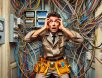 funny-electrician-tangled-wires A surprised electrician dealing with a hilariously tangled mess of wires in a residential electrical panel, capturing the chaotic reality of unexpected wiring disasters.