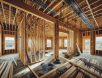 unfinished-home-construction-exposed-wiring-high-resolution High-resolution photograph of an unfinished home under construction, featuring exposed electrical wiring, wooden framing, and scattered building materials in a well-lit, sharp, and detailed setting.